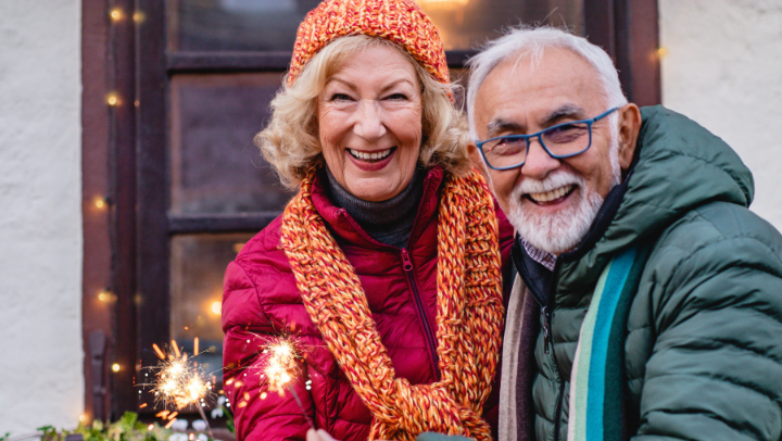 an elderly couple embracing each other and celebrating holidays