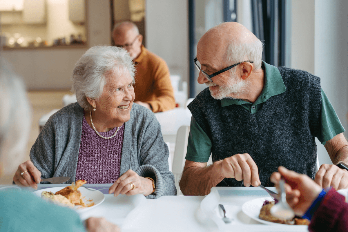 Elderly couple having lunch in community center cafeteria.
