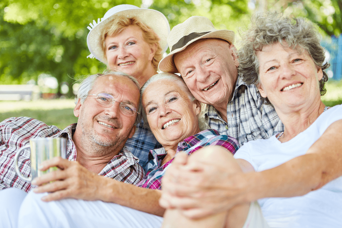 Happy seniors group as friends on a tour in summer in nature.